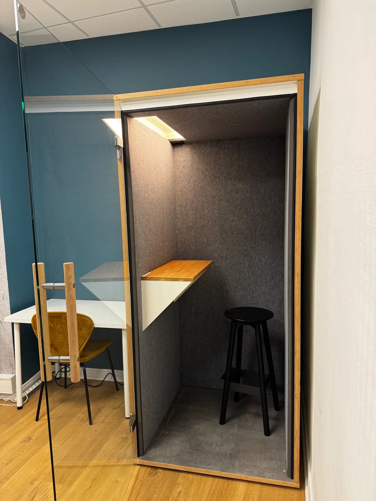 Cabine phonique ouverte avec éclairage, tablette et tabouret dans le coworking Les Barques